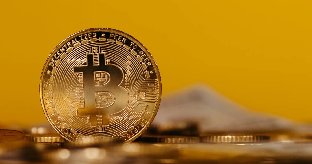 Detailed close-up image of a Bitcoin coin showcasing cryptocurrency with a bright yellow background.