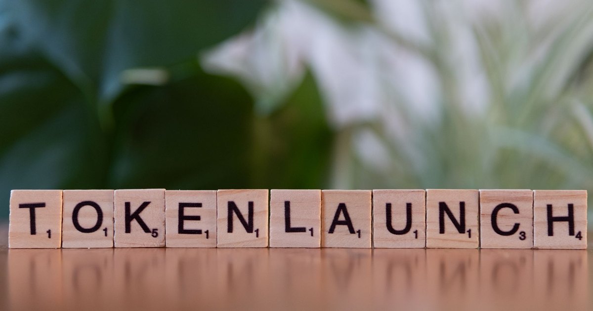 Scrabble tiles spelling 'Token Launch' on a vibrant green background.