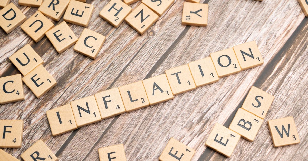Wooden letter tiles forming the word 'inflation' on a rustic wooden surface, symbolizing economic themes.
