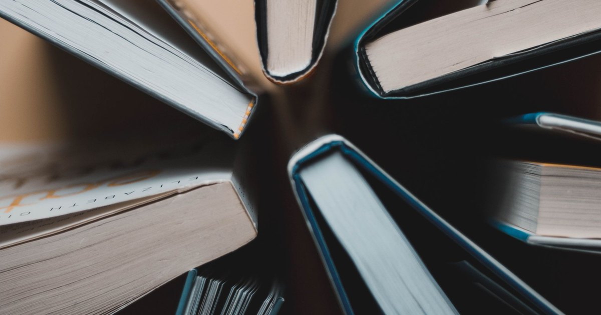 Top-down view of open books arranged in a circle showing spines and pages.