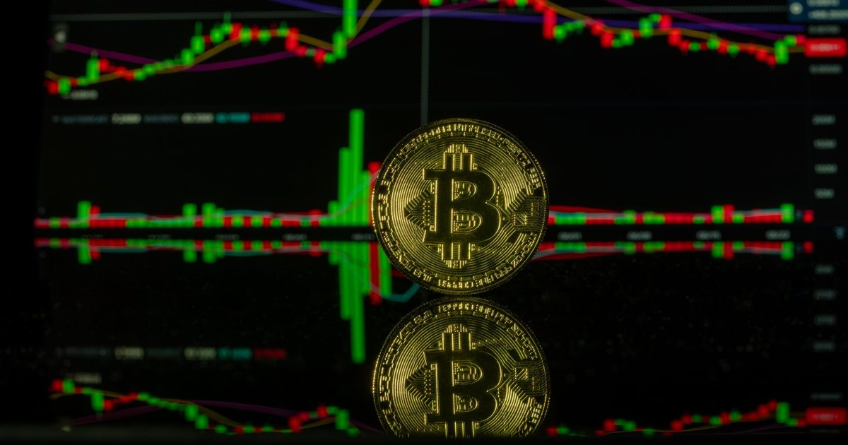 Bitcoin coin against a trading chart background showcasing market trends. Captured in Valencia.