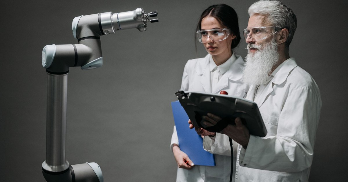 Researchers examining a robotic arm, showcasing technology and innovation.