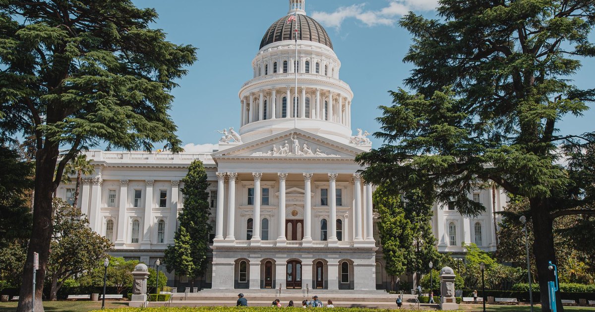 Majestic view of a historical capitol building surrounded by lush greenery.
