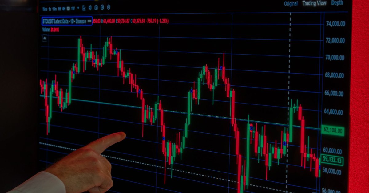 Hand pointing at Bitcoin price graph on screen, highlighting market trends and investment analysis.