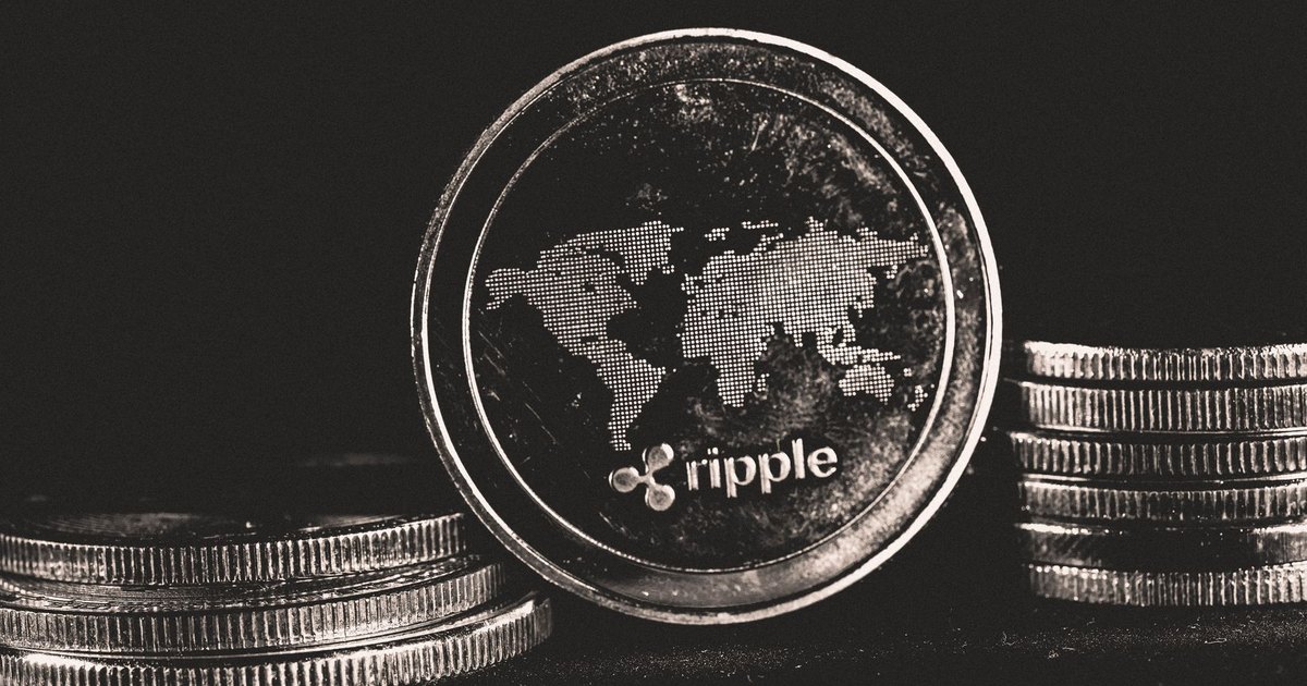 A detailed shot of a Ripple coin with a world map design on a black background.