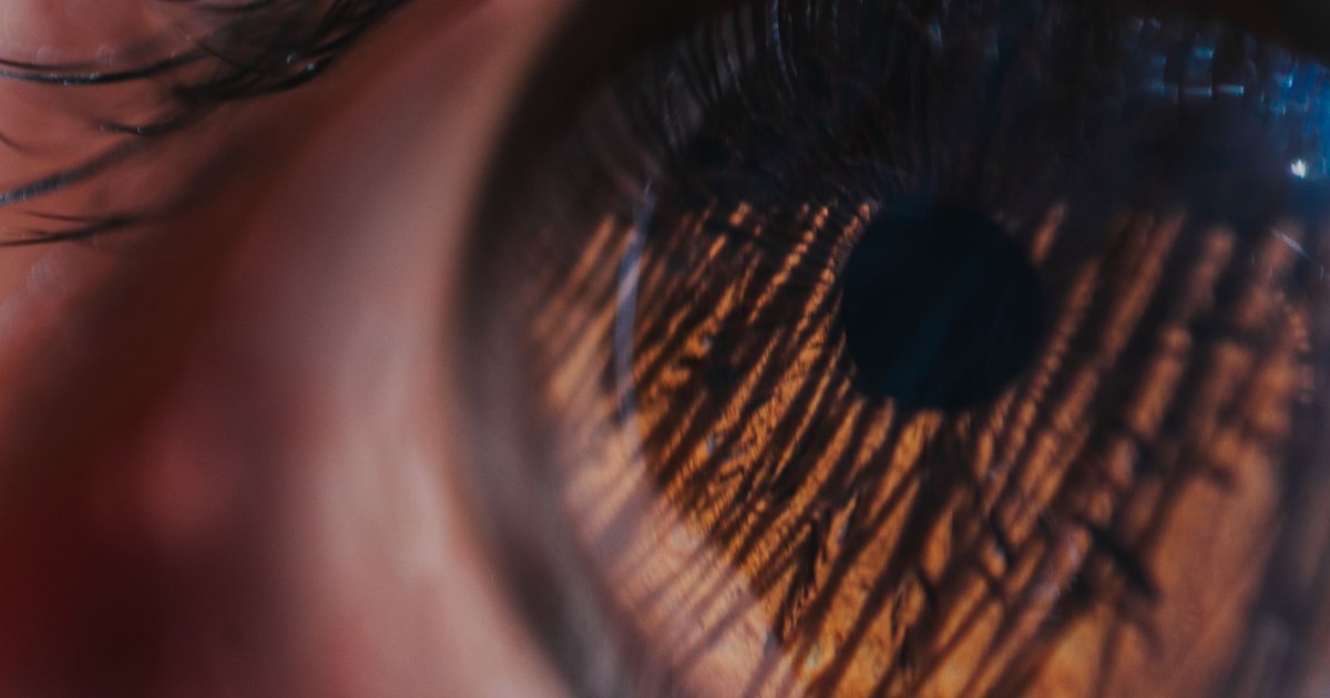 Detailed macro shot of an eye, showcasing the intricate patterns of the iris and reflections.