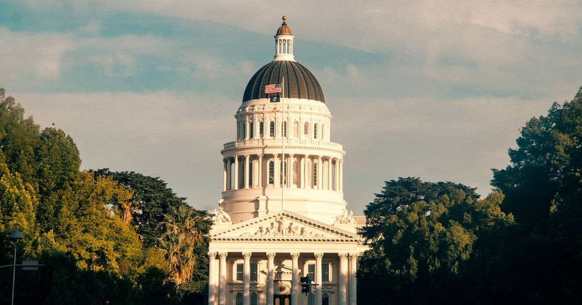 Captivating view of the California State Capitol amidst lush greenery under a clear sky.