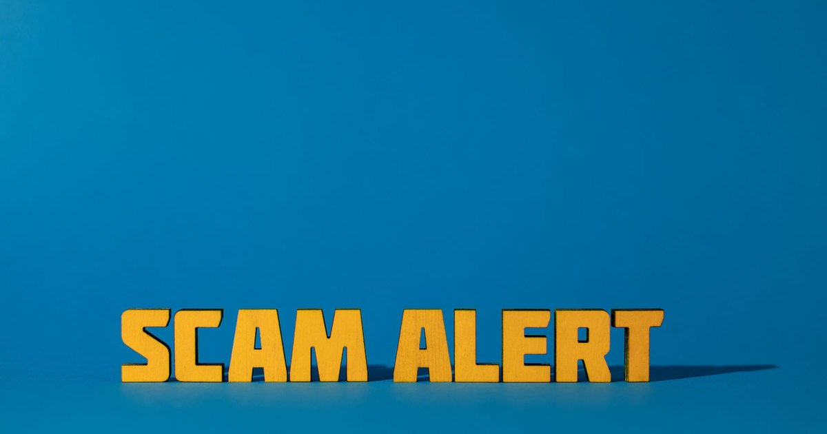 Bold yellow 'Scam Alert' text on a vivid blue surface, emphasizing warning and caution.