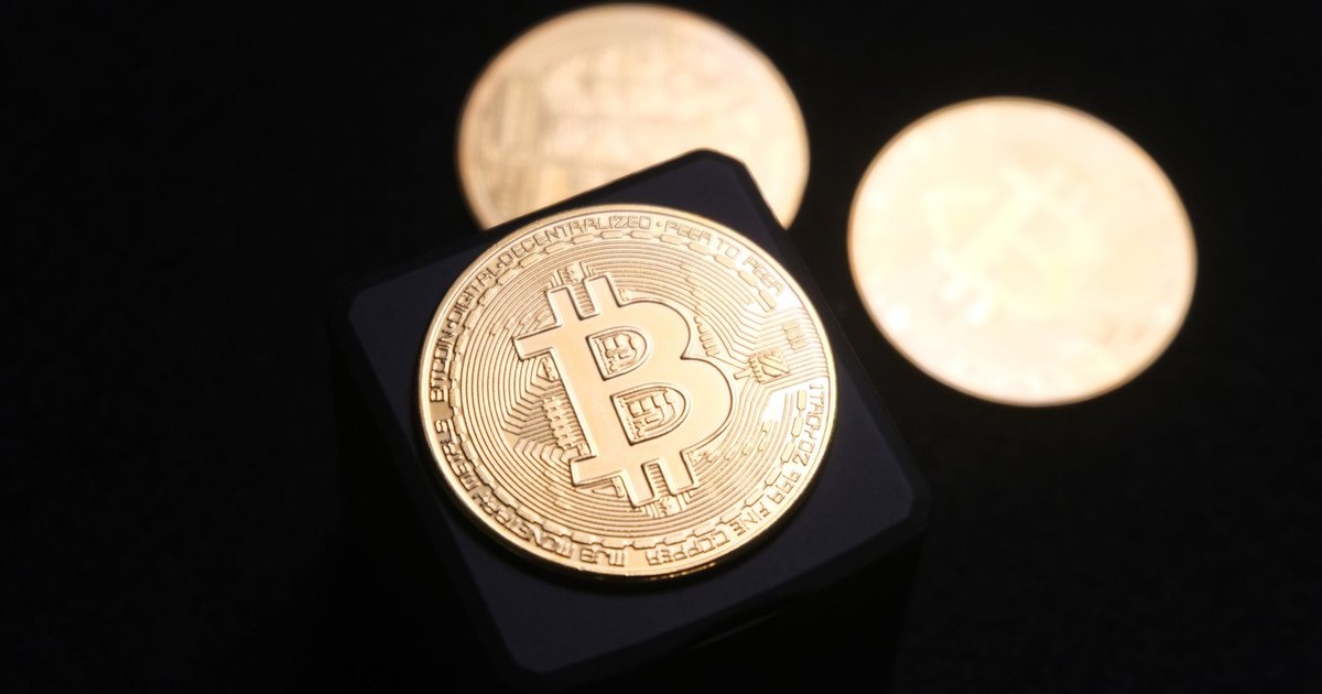 Close-up of golden Bitcoin coins on a sleek black background, emphasizing cryptocurrency themes.