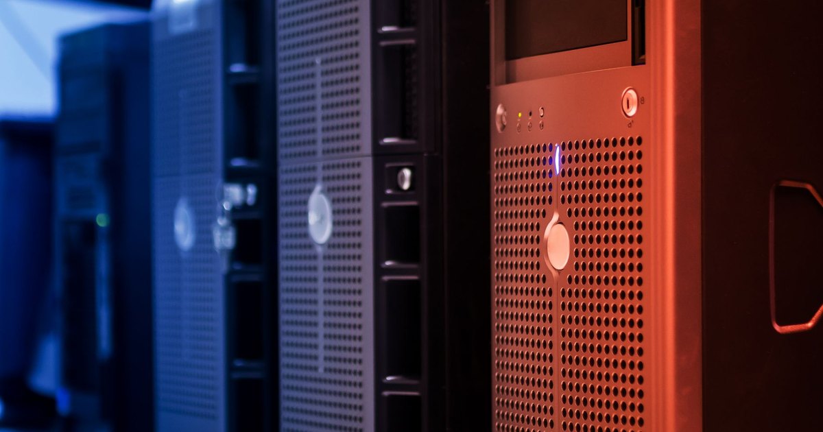 Close-up of tower servers in a data center with blue and red lighting.