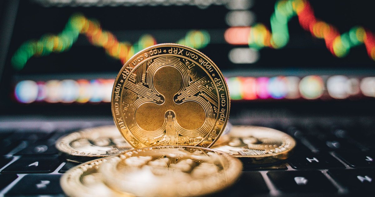 Golden Ripple XRP coins on laptop, symbolizing cryptocurrency trends and online trading.