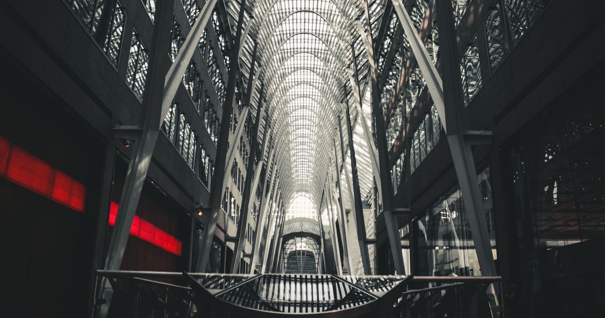 Impressive modern architecture featuring glass, steel, and light reflections in an urban setting.