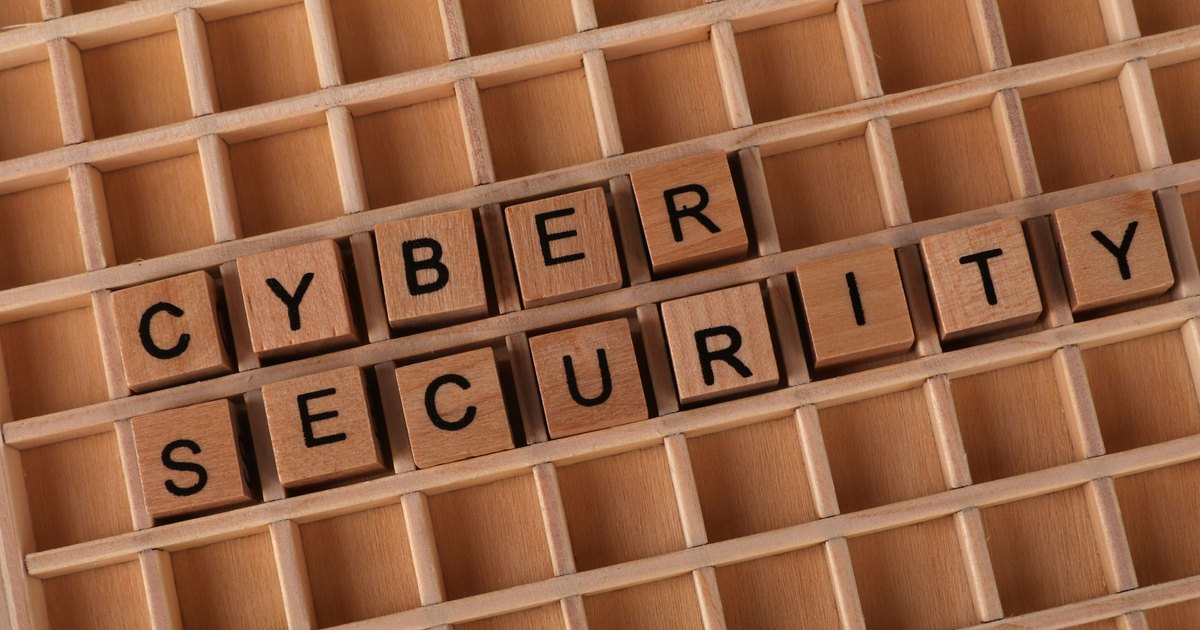 Wooden blocks spelling 'Cyber Security' on a wooden grid background.