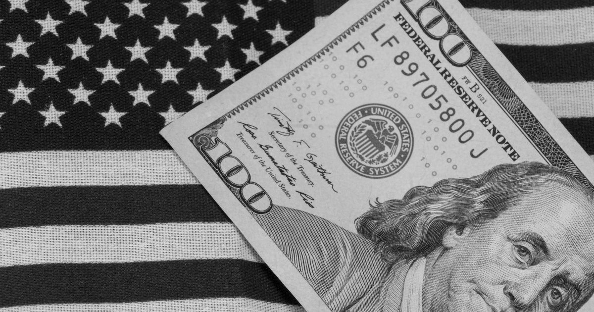 Grayscale image of US dollar bill on American flag for symbolic financial concept.